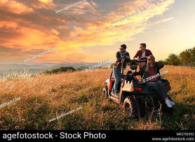 portrait of group young happy people enjoying beautiful sunny day while driving a off road buggy car on mountain nature