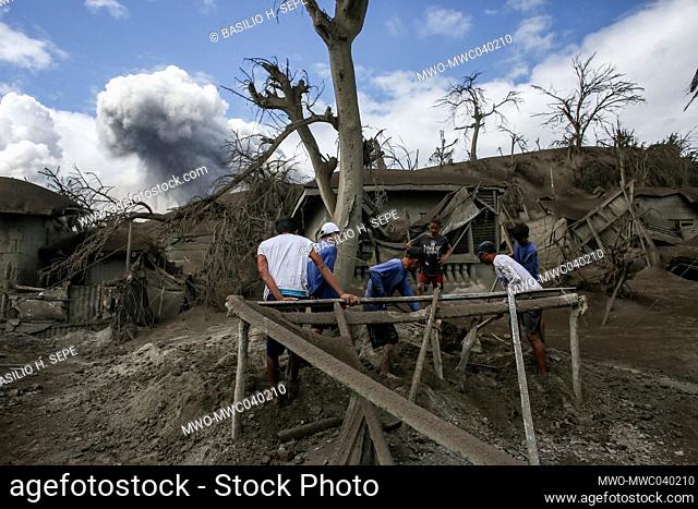 Damaged houses are covered in volcanic ash during an eruption in Tagaytay, Cavite province south of Manila. Taal Volcano is a large caldera filled by Taal Lake...