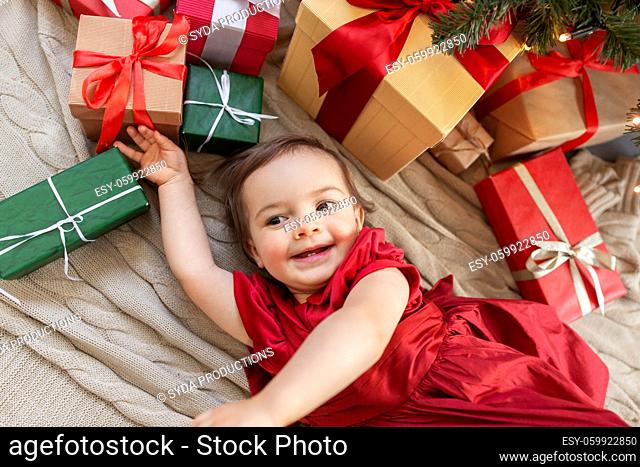 happy baby girl with christmas gifts at home