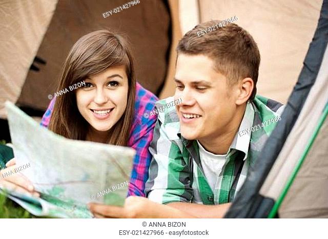 Couple looking at map in tent