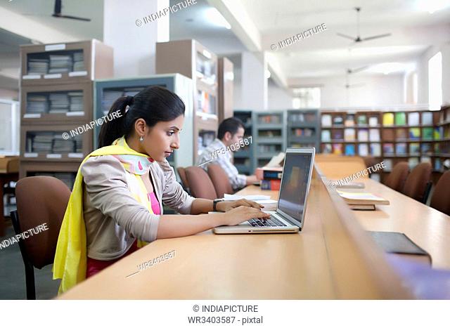 Girl with laptop in library