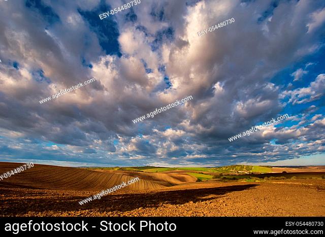 Rolling fields of South Moravia in the autumn morning with a sky full of fast-moving clouds after a storm, Moravian Tuscany, Czechia