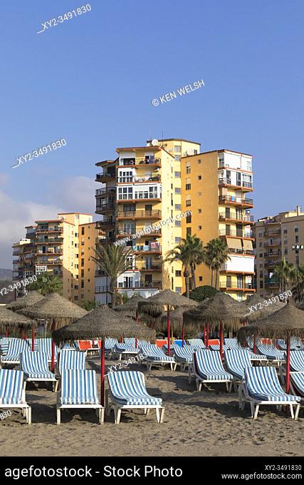 Torremolinos, Costa del Sol, Malaga Province, Andalusia, southern Spain. Rows of beach beds and umbrellas awaiting clients in the early morning on Playamar...