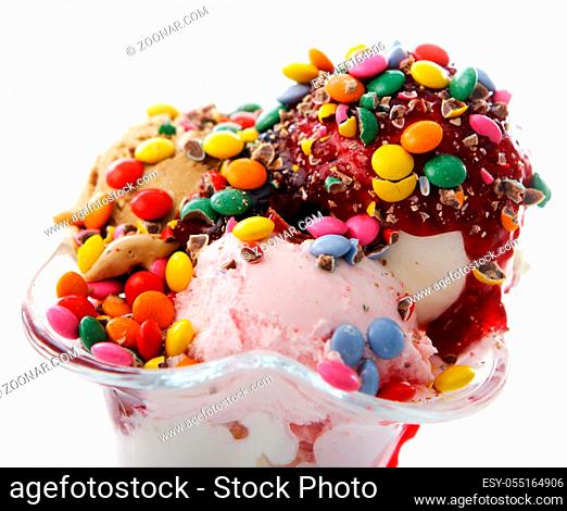 Ice cream dessert with colorful candies on white background