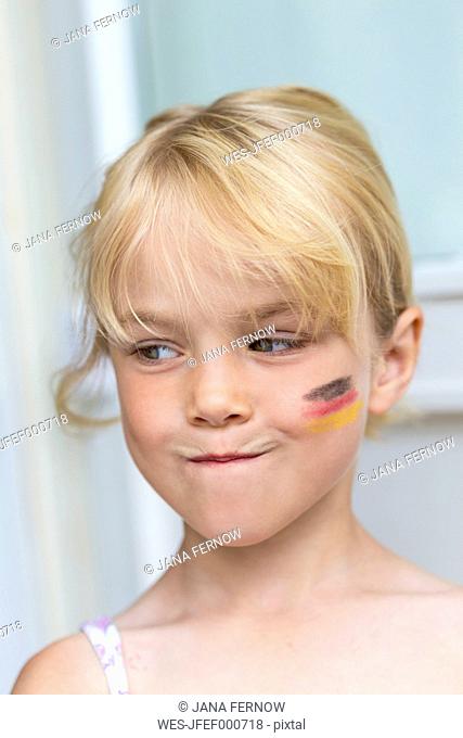 Portrait of blond little girl with German Flag painted on her cheek