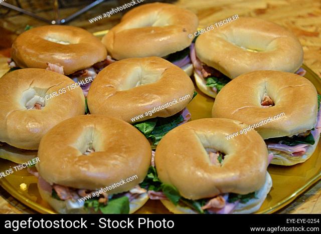 general view of a sandwich made with Bagel bread turkey ham, lettuce and garnished with a tomato / Eyepix Group
