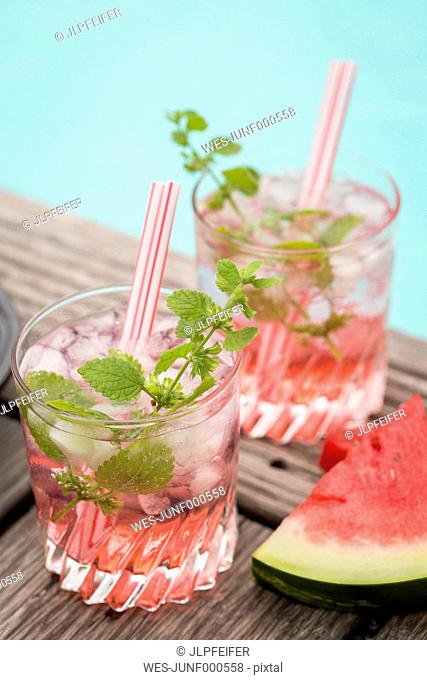 Fresh mineral water with watermelon, sirup and ice in glasses