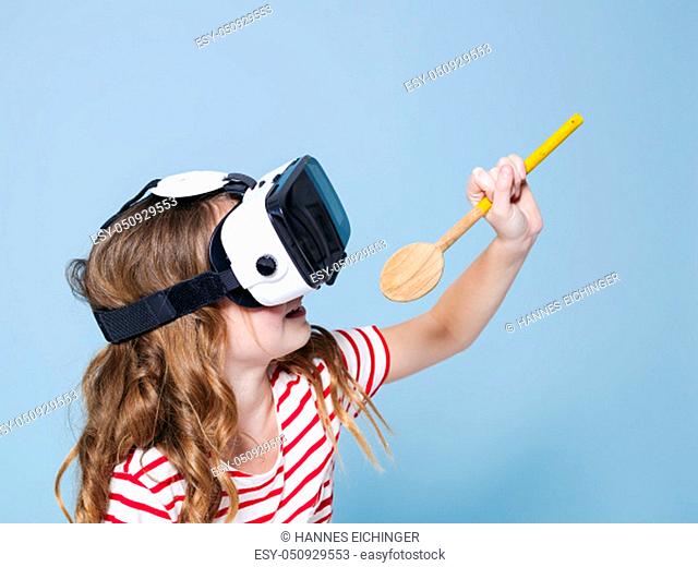 cool and smiling positive girl wearing virtual reality glasses goggles headset is singing with cooking spoon, new generation