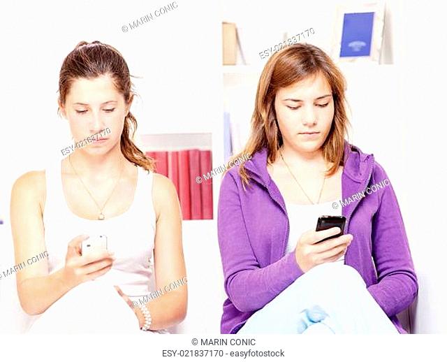 Two teenage girs with mobile phones