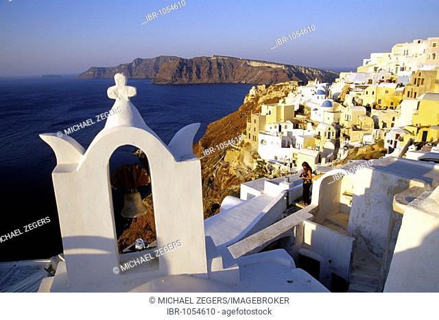 Village of Oia with its white houses, church and view of the caldera, Island of Therasia, Thirasia in the back, Island of Santorini, Thera or Thira, Cyclades