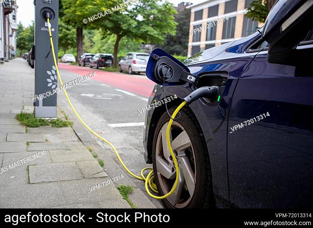 An electric vehicle connected to a charger pictured in Gent on Sunday 13 August 2023...BELGA PHOTO NICOLAS MAETERLINCK