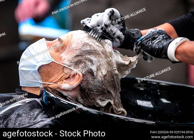 04 May 2020, Mecklenburg-Western Pomerania, Greifswald: Yvonne Gossau washes the hair of her customer Gerda Papke in the HARRgenau salon with one of the...