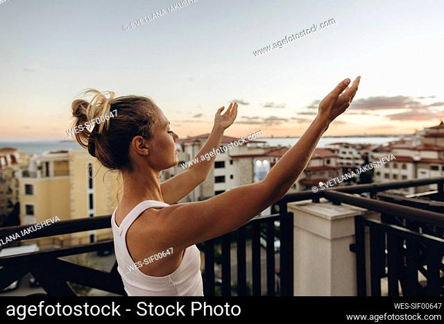 Serene woman enjoying the sunset on roof terrace