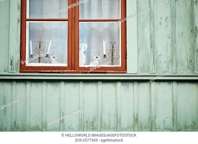 Christmas decorations and candles in window of traditional wooden house, Stockholm, Sweden, Scandinavia