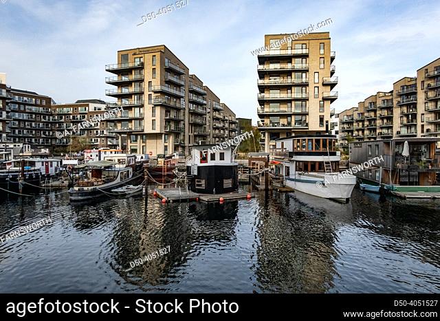 Copenhagen, Denmark Houseboats parked in a canal with modern residential buildings in the Sydhavn or South Harbor distrct