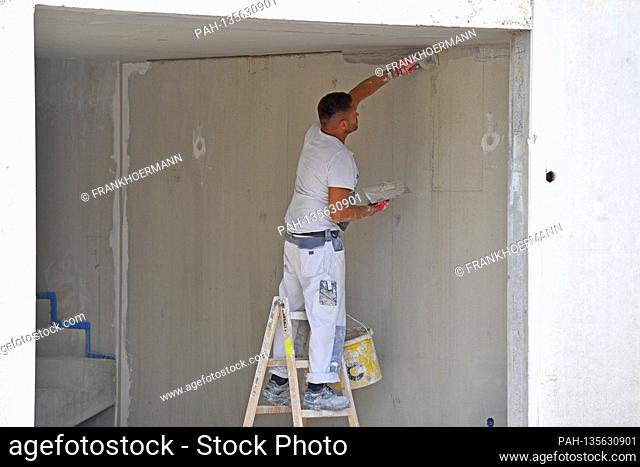 Construction workers on a large construction site, workers grouting concrete walls, prefabricated walls. New apartments, shell construction, scaffolding