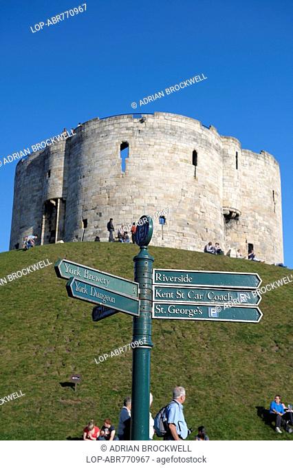 England, North Yorkshire, York, Clifford's Tower, one of the principal remains of York castle, with a tourist sign post in the foreground