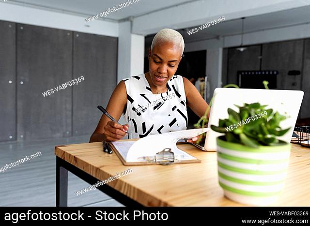 Businesswoman working in modern office, using laptop