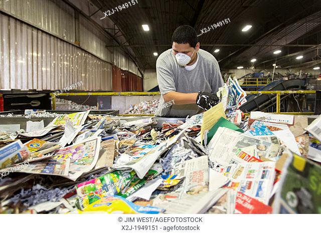 Troy, Michigan - Low-wage workers sort paper, glass, plastic, and metals for recycling at the Southeastern Oakland County Resource Recovery Authority