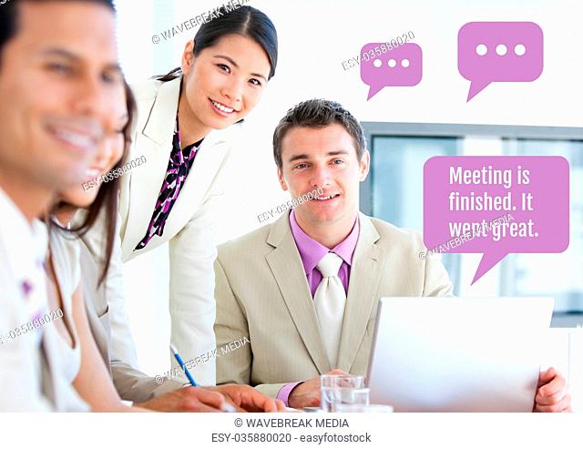 Business people at meeting on laptop with chat bubbles