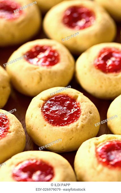 Thumbprint Christmas cookies filled with strawberry jam, photographed with natural light (Selective Focus, Focus one third into the image)