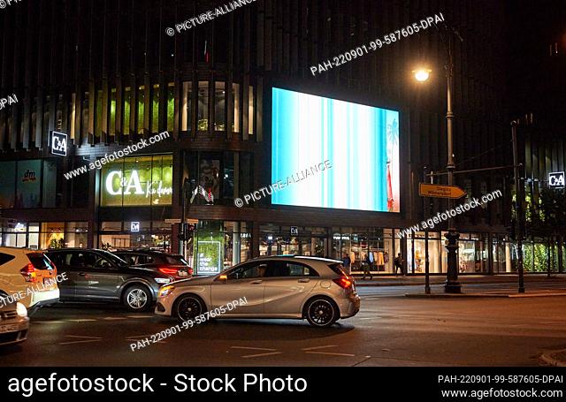 PRODUCTION - 28 August 2022, Berlin: A large illuminated billboard on Tauenzienstrasse shines next to C&A at the intersection
