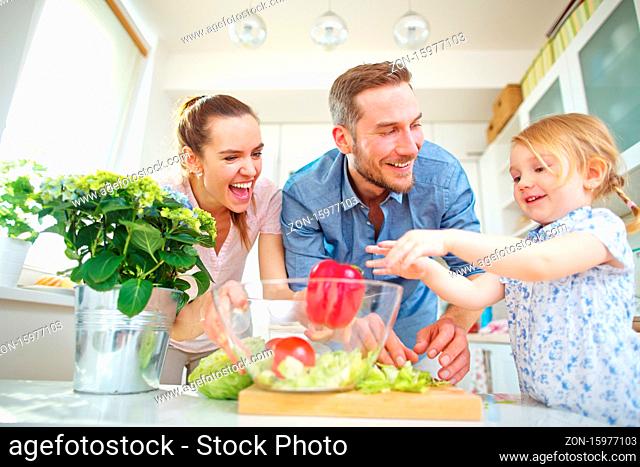 Kind in der Familie hilft beim Salat machen in der Küche