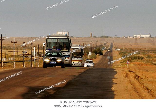 The prime and backup crew buses are escorted through the Baikonur Cosmodrome as the crew returns to the Cosmonaut Hotel. Astronaut Leroy Chiao