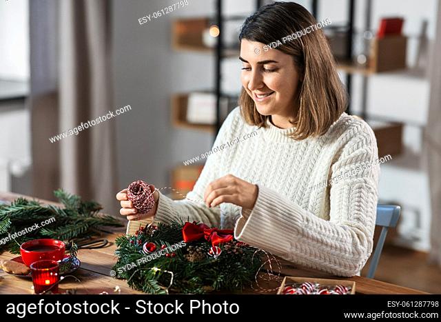 woman making fir christmas wreath at home