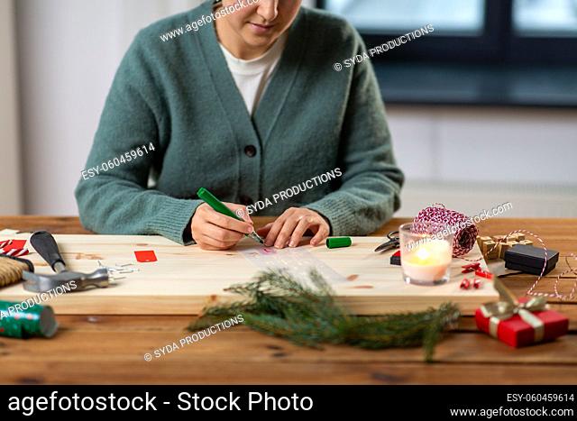 woman with stencil and marker drawing on christmas
