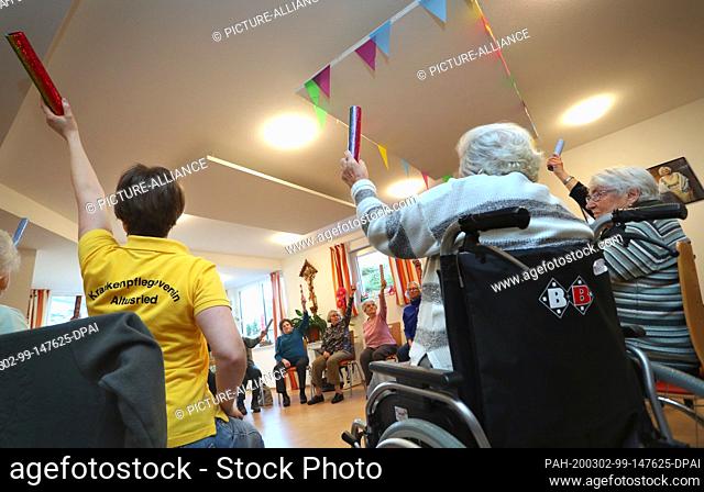 21 February 2020, Bavaria, Altusried: Senior citizens sit together in the dementia residential community during a guided sitting gymnastics