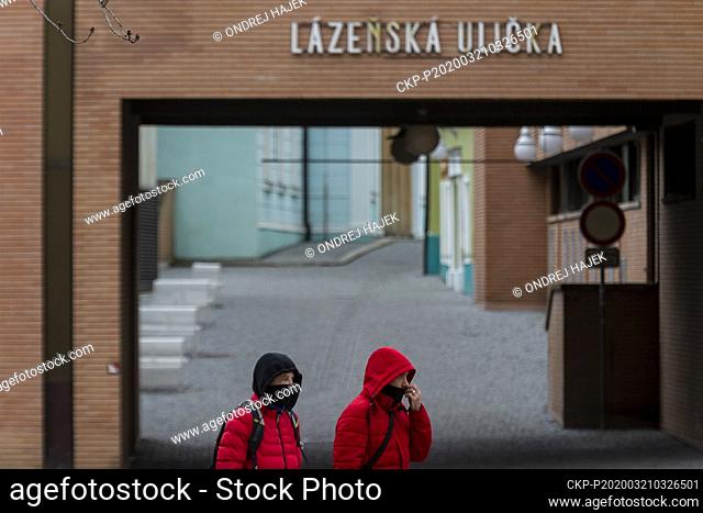 A pair of pedestrians with protection face masks is seen on March 21, 2020, in Teplice, Czech Republic. People can only appear in pairs in public spaces since...