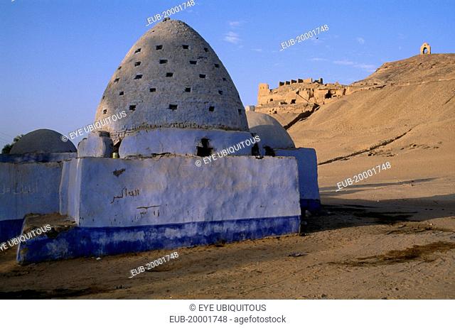 Blue painted Beehive Mausoleum with Tomb of the Nobles on hilltop behind