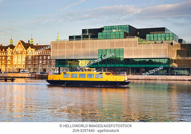 Ferry boat in front of the Danish Architecture Centre (DAC) at sunrise, Copenhagen, Denmark, Scandinavia. The harbour buses operated by Movia are integrated in...