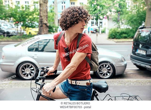 Young man riding bicycle on pavement turning around