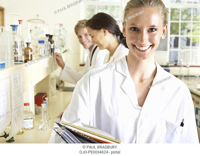Woman in a laboratory with two people in the background