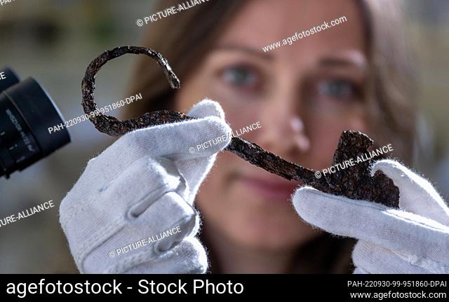 PRODUCTION - 29 September 2022, Saxony-Anhalt, Halle (Saale): Restorer Vera Keil examines a large iron key in the workshop of the Saxony-Anhalt State Office for...