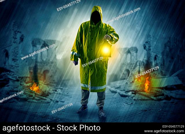 Destroyed place after a catastrophe with man in raincoat and lantern concept