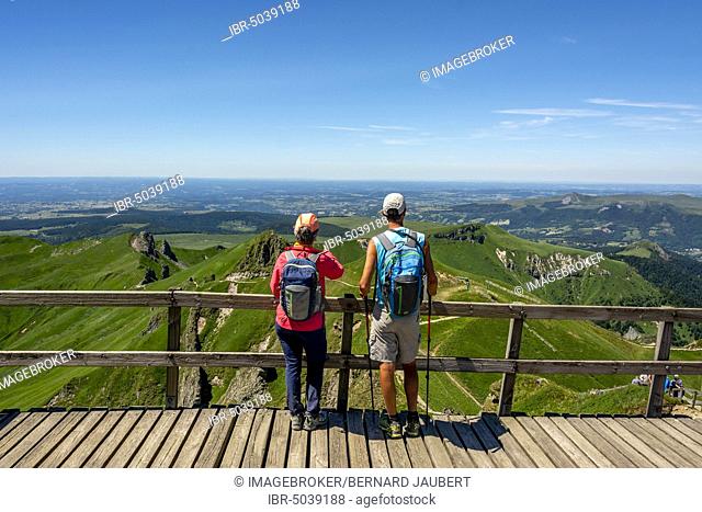 Hiker looking at the mountains of Massif of Sancy, Auvergne Volcanoes Natural Regional Park, Auvergne, France, Europe