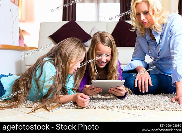 Familie spielt mit dem Tablet computer daheim Family playing with Tablet comput