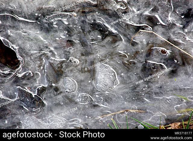 Eiskristalle wachsen bei Dauerfrost von den Ufern über einen kleinen Bach, Nordrhein-Westfalen, Deutschland, Weilerswist