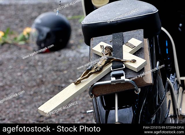 15 October 2023, Saxony-Anhalt, Oschersleben: A Jesus cross lies on the luggage rack of a moped for the biker service. The invitation to the EKM biker service...