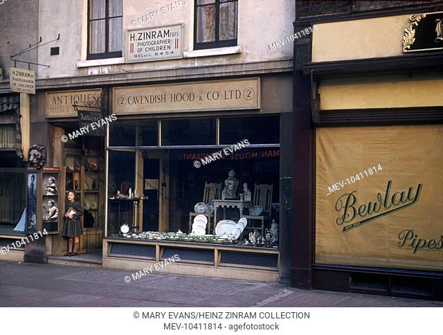 A view of Heinz Zinram's photography studio, above the Cavendish Hood antique shop at No. 2 Baker Street, London. Examples of his photography of children are on...
