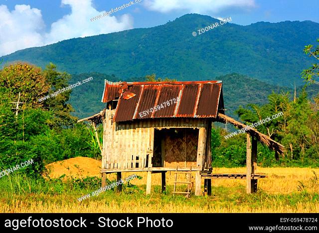 Farmer's hut on a field in Vang Vieng, Laos. Vang Vieng is a popular destination for adventure tourism in a limestone karst landscape