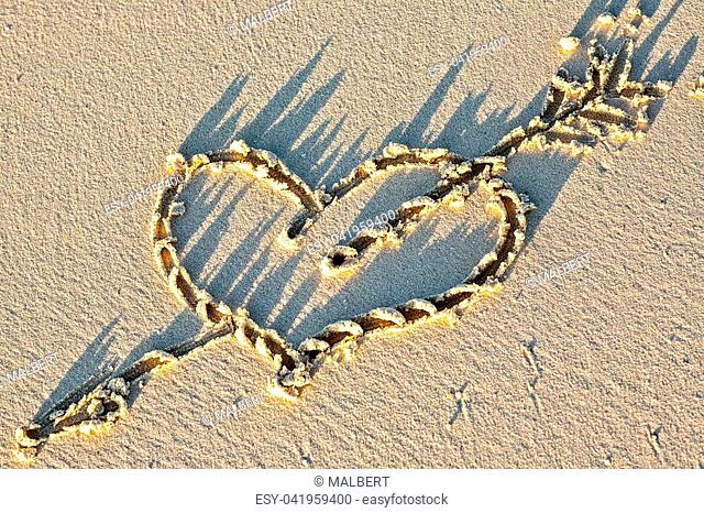 Heart on a sandy sunset beach