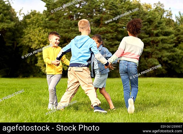 happy children playing round dance at park