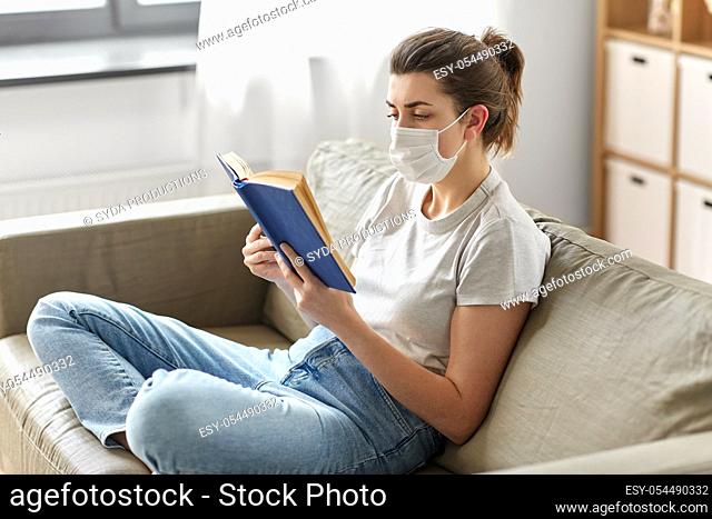 sick woman in medical mask reading book at home