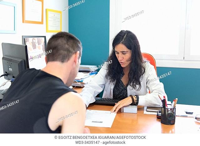 A female nutritionist and his male client talking in an office
