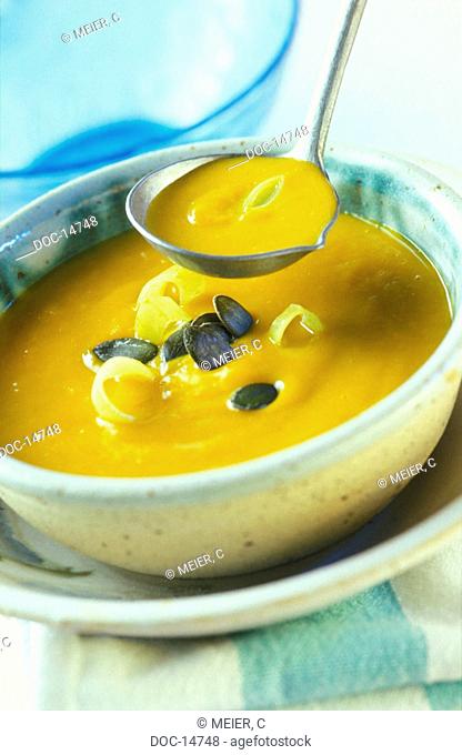 Pumpkin creme soup garnished with pumpkin seeds and leek