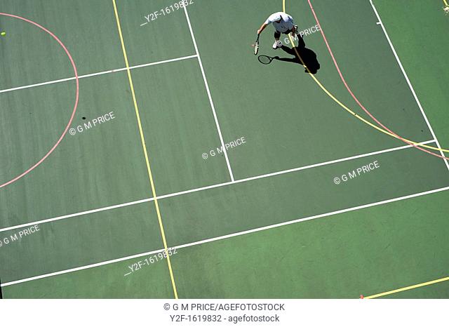 man playing tennis on tennis and basketball court